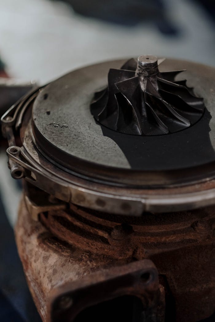 our-story Detailed shot of a rusty turbocharger showing metal components and engine parts.